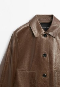 Veste marron en similicuir à manches longues avec col pointu, trois boutons noirs à l'avant et deux poches avant, étiquetée Massimo Dutti.