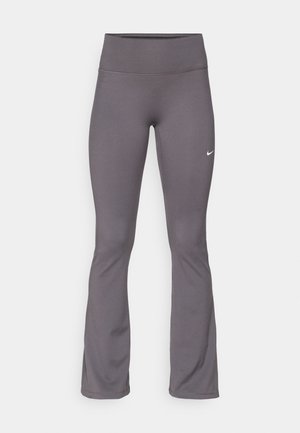 Grå utsvängda leggings i stretchigt material, med hög midja och en liten vit logotyp på vänster lår. Slät textur överlag.