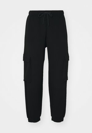 Sorte sweatpants lavet af blødt stof, med to sidelommer, en elastisk talje med snor og tætsiddende manchetter.