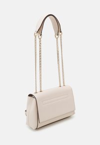 Beige handväska med en strukturerad yta, rektangulär form, guldkedjestroppar och en platt framficka; minimalistisk design och rena linjer.