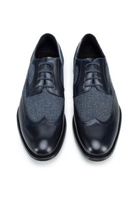 Zapatos de cuero azul oscuro con una parte superior de tela de espiga. Presentan un diseño clásico de brogue y cinco ojales, acabado suave y suelas robustas.