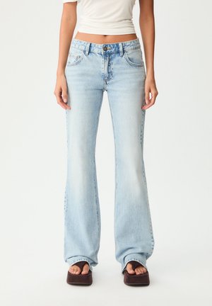 Helle blaue, aus Denim gefertigte Schlagjeans mit fünf Taschen, sichtbaren Nähten und einem leicht ausgewaschenen Finish.