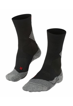 Schwarze Socken mit gerippter Textur, grauem verstärktem Zeh und Ferse, versehen mit weißen geometrischen Akzenten und einem roten Logo am Knöchel.