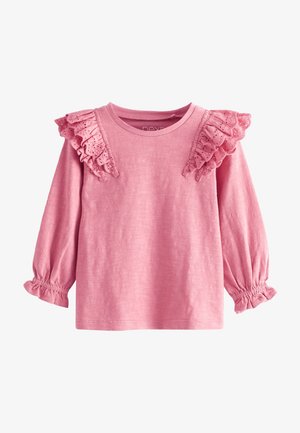 Rosa Langarmshirt für Kleinkinder mit Rüschen aus Lochspitze an den Schultern und elastischen Bündchen mit kleinen Rüschen.