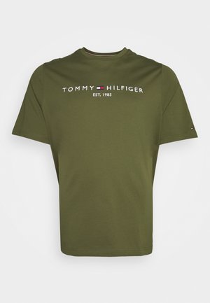 T-shirt manches courtes vert olive avec « Tommy Hilfiger EST. 1985 » et un petit drapeau du logo de la marque sur la poitrine et la manche.