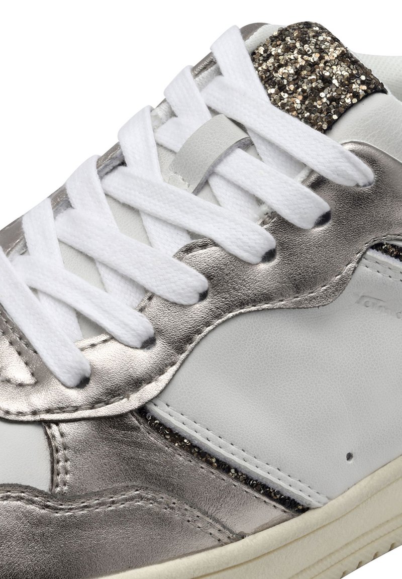 Witte sneaker met metalen zilveren accenten en een glinsterend detail op de hiel, voorzien van witte veters en een textuur van leren afwerking.