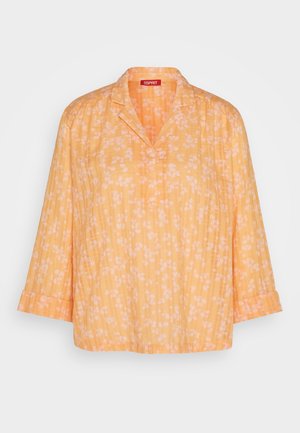 Blouse à imprimé floral jaune avec un col et des manches trois-quarts, réalisée dans un tissu léger et une coupe décontractée.