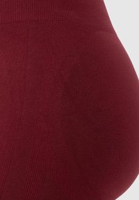 Burgundowe legginsy ciążowe z fakturowanej tkaniny, z prążkowanym paskiem w talii, gładkim wykończeniem i dopasowanym krojem dla komfortu.