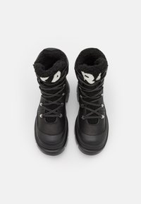 Par de botas de invierno negras con cuero texturizado, suelas gruesas, cordones grises y forro de forro polar negro visible en la parte superior sobre un fondo blanco.