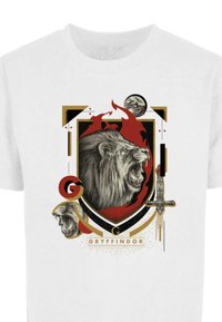 Balta marškinėliai su Gryffindor emblema, turinčia riaumojantį liūtą, kardą, raudonus ir auksinius akcentus bei sudėtingus grafikos elementus.
