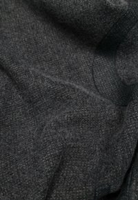 Šedá texturovaná tkanina s jemným tkaným designem a subtilními vzory, která má mírný lesk a vytváří teplý, hmatový vzhled.