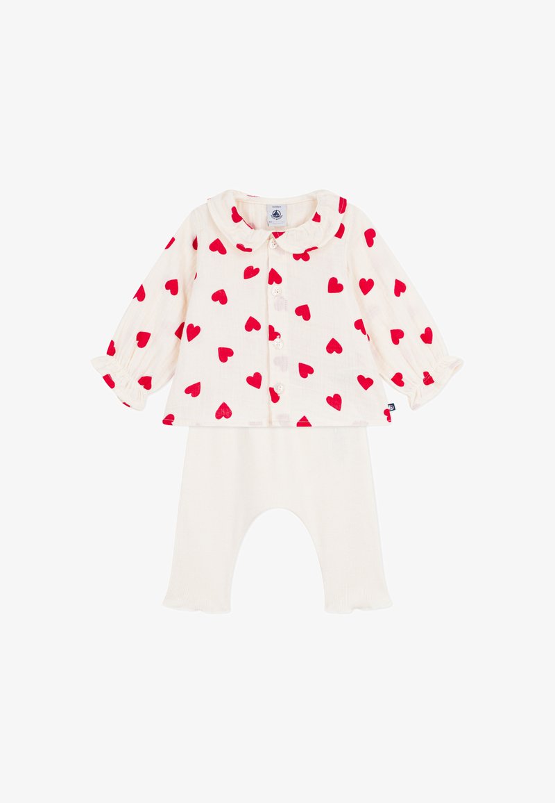 Weißes Langarmshirt mit rotem Herzmuster, Peter-Pan-Kragen und Knopfverschluss, kombiniert mit weichen, hellfarbenen Leggings.