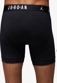 Fekete pamut boxer alsónadrág, logóval kiemelt gumírozott derékkal. Simaság jellemzi, testhezálló fazon, amely a comb közepéig ér.