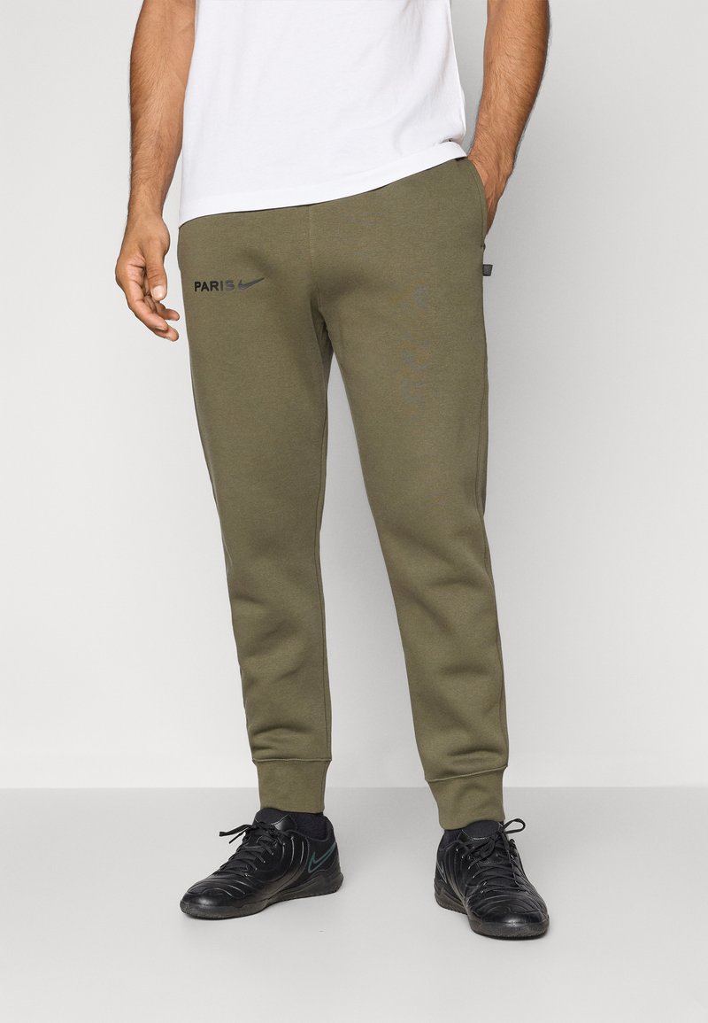 Soutiens de treino verde-oliva com um design levemente afunilado, apresentando os logótipos em preto "PARIS" e Nike, bolsos laterais e punhos canelados; tecido texturizado.