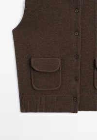 Cardigan sans manches en maille marron foncé avec boutons à l'avant et deux poches à rabat près de la taille.