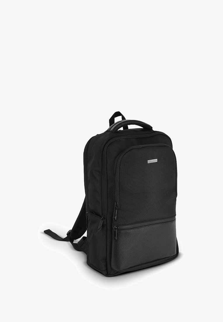 Czarny plecak z teksturowanej tkaniny i gładkim skórzanym dnem, z podwójnymi komorami zapinanymi na zamek błyskawiczny i regulowanymi, wyściełanymi paskami.