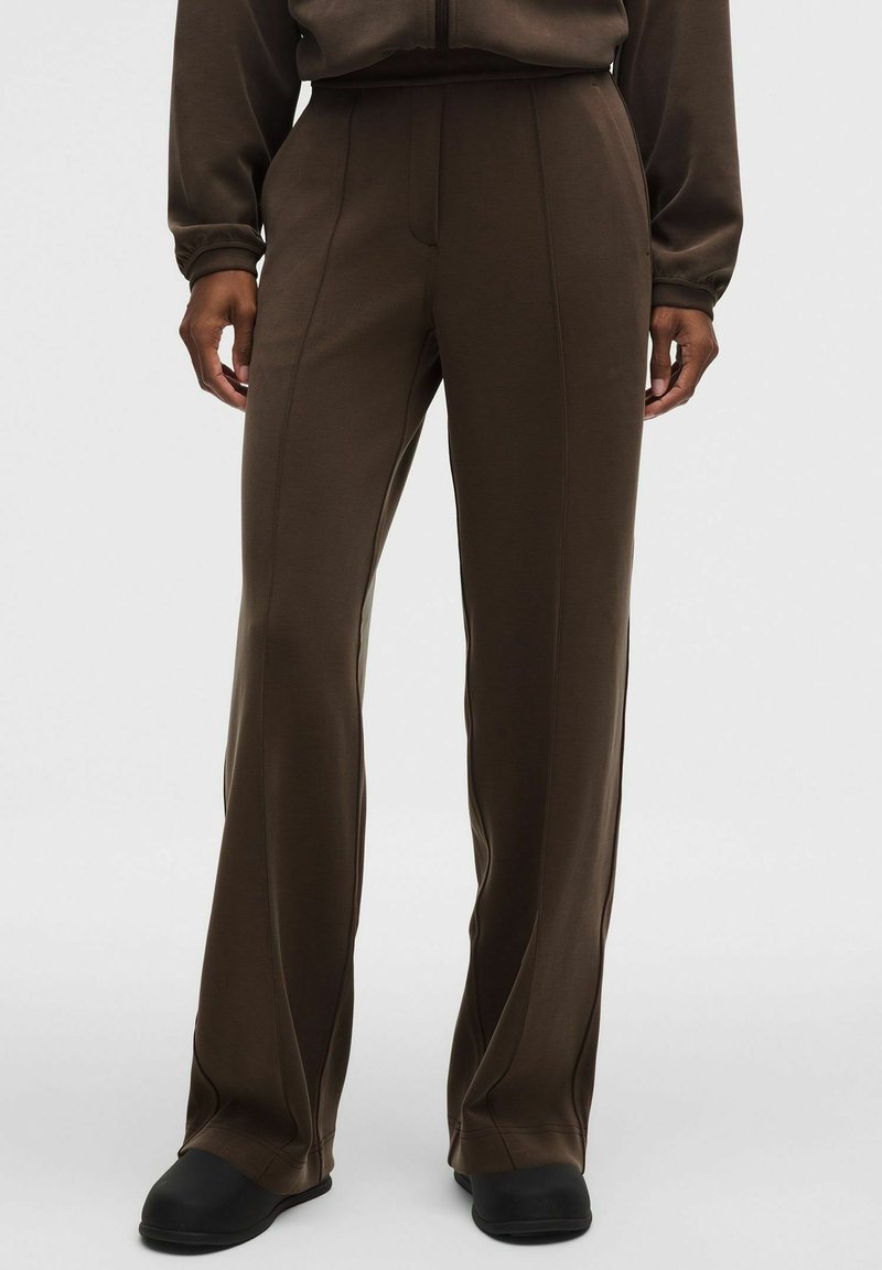 Pantalones de chándal marrones con un diseño de pierna recta, hechos de una tela suave. Presentan costuras sutiles para dar estructura y una cinturilla ancha para mayor comodidad.