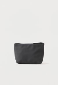 Mala crna tkanina sa zipom, s pravokutnom bazom, stoji uspravno na bijeloj površini.