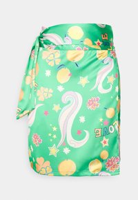 Gonna avvolgente verde realizzata in tessuto morbido, con una stampa colorata di fiori, stelle e forme astratte, con accenti di arancione e rosa.