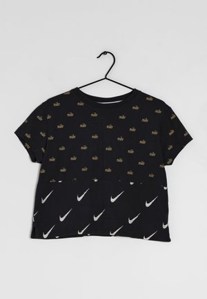 Maglietta nera corta con maniche corte, caratterizzata da testo "nike" dorato ripetuto e loghi swoosh bianchi di Nike in un motivo sparso.