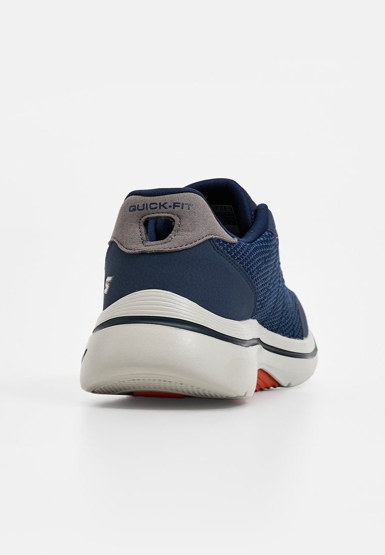 Zapatillas de malla en color navy con detalle gris en el talón, que cuentan con un bucle "Quick-Fit" para un ajuste rápido, suela acolchada y detalles en rojo en la suela.