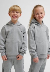 Szare bluzy z kapturem wykonane z miękkiej tkaniny, z przednimi kieszeniami i ściągaczami. Dwoje dzieci uśmiechających się, noszących dopasowane spodnie dresowe.