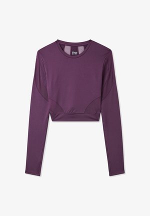 Cropowana bluzka z długim rękawem w głębokim fioletowym kolorze, wykonana z gładkiego materiału, z siateczkowymi akcentami i okrągłym dekoltem.