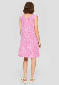 Abito rosa a lunghezza ginocchio con motivi floreali bianchi, maniche a cappuccio e design a V sulla schiena, realizzato in tessuto leggero. Accentuato da una vestibilità morbida.
