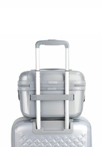 Conjunto de maletas duras de color gris con un diseño texturizado y en ángulo. Cuenta con un asa retráctil y una correa de transporte superior para mayor comodidad.