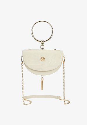 Sac à main crème texturé en forme de demi-lune avec poignée circulaire dorée sur le dessus, bandoulière chaîne dorée, détail pompon et petite fermeture logo dorée au centre devant.