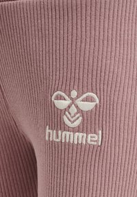 Rosa ribbad tyg med en broderad vit logotyp som har en stiliserad bie och ordet "hummel" placerat i den nedre mitten.