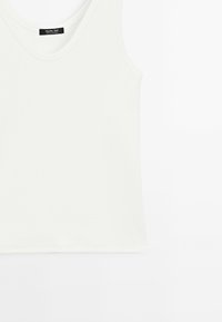 Witte mouwloze geribbelde tanktop met een ronde hals en het Massimo Dutti-label in de kraag.