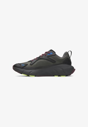 Sportieve schoen met een bovenwerk van zwart en grijs mesh, verfraaid met blauwe accenten, een dikke zwarte tussenzool en een rubberen buitenzool met groene details.