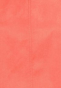 Tissu de corail doux avec une couture verticale visible courant au centre, montrant des détails de couture fins et une texture lisse.