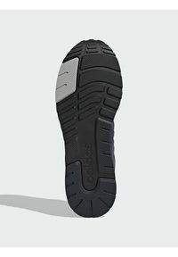 Melnas gumijas sporta apavu zole ar teksturētu saķeres rakstu, ar pelēku akcentu un "adidas" zīmolu iespiestu apakšējā daļā.
