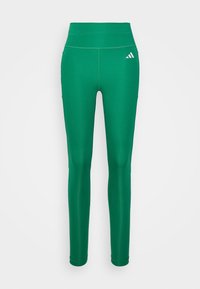 Zielone legginsy sportowe z wysokim stanem, gładką strukturą, dopasowanym krojem i białym akcentem w postaci logo Adidas na górnej lewej stronie.