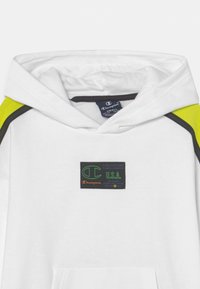 Felpa bianca con cappuccio e dettagli verde lime, con piping nero. Presenta un grande patch con il logo Champion e del testo sul davanti.