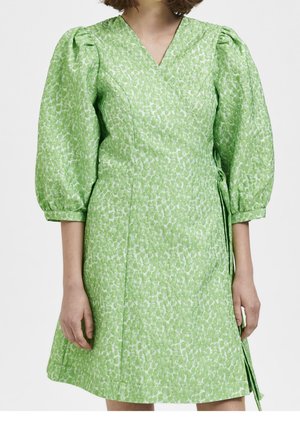Robe d'env. verte à motif floral, avec des manches bouffantes à trois quarts et un décolleté en V, portée par une personne debout sur fond blanc.