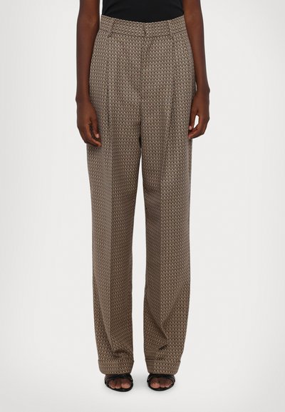 Des pantalons larges à motifs marron présentent une taille haute, des plis et un motif géométrique. Texture lisse avec un léger éclat.