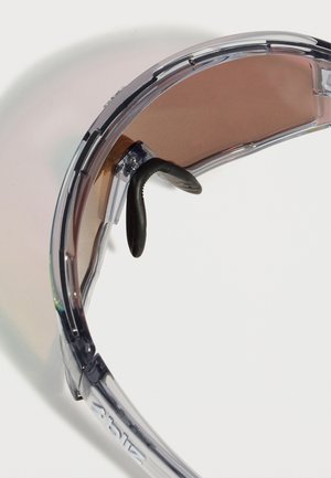 Διάφανα προστατευτικά γυαλιά με σκουρόχρωμους φακούς και ρυθμιζόμενες μαύρες μύτες, εμφανίζονται σε λευκό φόντο.