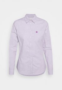 Chemise à manches longues et à boutons de couleur lilas clair avec des rayures blanches. Elle dispose d'une poche poitrine unique et d'un petit logo brodé. Texture en coton lisse.