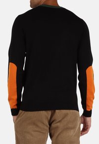 Maglione nero a maglia con toppe sui gomiti arancioni a contrasto e colletto verde. Tessuto testurizzato con polsini e orlo a costine. Vestibilità casual.