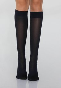 Černé vysoké ponožky vyrobené z průhledného materiálu s hladkou texturou, s pevným lemem nahoře pro bezpečné nošení a pohodlí.