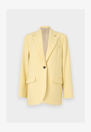 Blazer jaune pâle à un bouton avec revers crantés, deux poches à rabat à l'avant et une poche poitrine passepoilée, présenté sur un fond neutre.
