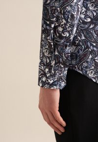 Camicia a maniche lunghe con un vivace motivo paisley nelle tonalità di blu e bordeaux, realizzata in tessuto morbido, con polsini abbottonati e orlo dritto.