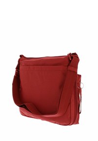 Sac messager en tissu rouge avec une surface texturée, une bandoulière ajustable et une poche avant. Il dispose d'une fermeture éclair et de détails en métal.