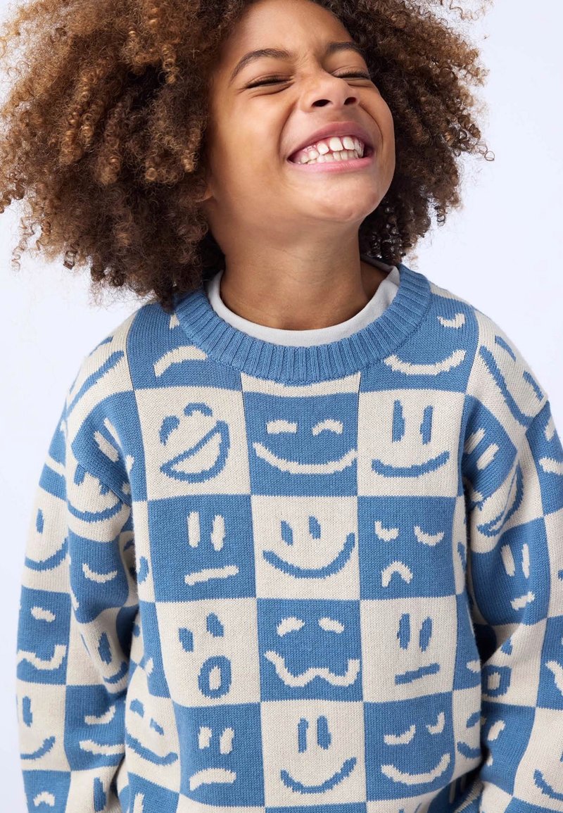 Strickpullover mit einem Blockmuster aus verschiedenen Smileys in Blau- und Cremetönen. Rundhalsausschnitt, strukturiertes Material, verspieltes Design.