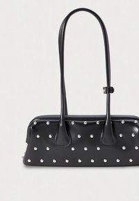 Melna ādas soma ar divām rokturiem, priekšpusē rotāta ar sudraba punktiem. Taisnstūra formas ar gludu tekstūru un vienkāršu dizainu.