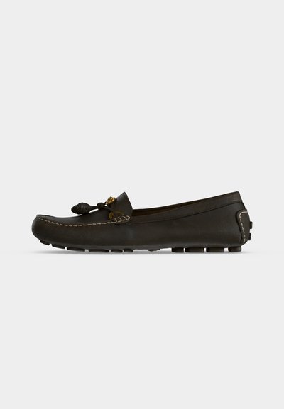 Mocassin en cuir noir avec bout cousu, nœud décoratif et semelle en caoutchouc cloutée, vu de côté gauche sur fond blanc.