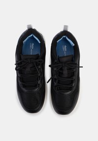 Baskets de sport noires avec une tige en maille et synthétique, avant rond, semelle flexible et doublure en tissu bleu. Elles sont dotées d'une languette et d'un système de laçage.